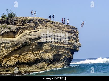 Bronzer, explorer les formations rocheuses, surfer et plonger depuis les falaises le long de Poipu Beach sur l'île de Kauai à Hawaï. Banque D'Images