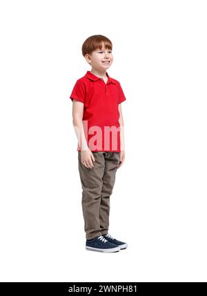 Petit garçon en polo rouge et pantalon beige sur fond blanc Banque D'Images