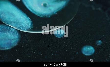 Gouttelettes d'huile gel liquide blob bleu peinture eau sombre Banque D'Images