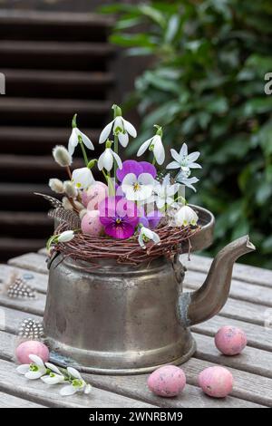 arrangement inférieur avec fleurs d'alto, gouttes de neige, flocons de neige et œufs de caille dans une ancienne théière Banque D'Images