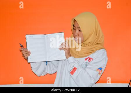 16 septembre 2023, photo d'une femme musulmane portant un livre, Wonosobo, Indonésie Banque D'Images