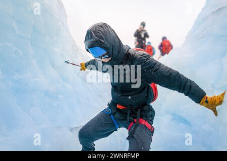 Homme descendant la crevasse du glacier à l'aide de cordes. Personne méconnaissable prenant des photos à l'aide d'un smartphone. Sortez de la randonnée sur glace Glacier. Alaska. Banque D'Images