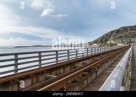 Vue depuis le pont de Barmouth, voies ferrées traversant l'estuaire Afon Mawddach vers le port, Gwynedd au nord-ouest du pays de Galles au Royaume-Uni. Mars 2024 Banque D'Images