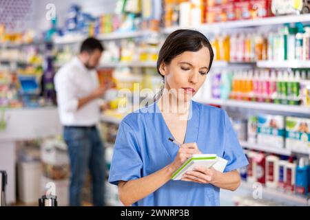 Pharmacienne femme vérifiant l'assortiment de médicaments en pharmacie en gros plan Banque D'Images