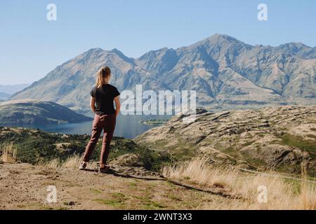 Femme regardant les hautes montagnes NZ et l'eau calme Banque D'Images