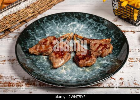 Côtelettes d'agneau fraîchement grillées. Tranches de côtelettes d'agneau cuites sur fond de bois. photo de haute qualité Banque D'Images