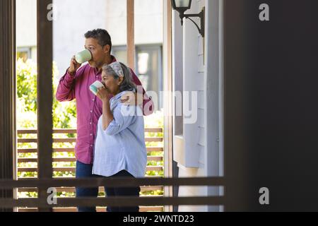 Femme biraciale senior et homme biracial profiter d'un moment paisible sur un porche avec espace de copie Banque D'Images