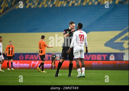 LVIV, UKRAINE - 3 MARS 2024 - Un arbitre met en garde l'attaquant Prince Kwabena Adu du FC Kryvbas Kryvyi Rih lors du match de la première Ligue ukrainienne 2023/2024 contre le FC Shakhtar Donetsk à l'Arena Lviv, Lviv, dans l'ouest de l'Ukraine. Banque D'Images