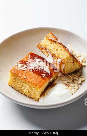 Gâteau israélien aux agrumes. Gâteau à la livre d'orange avec yaourt, amandes et sirop, fond blanc, gros plan. Banque D'Images