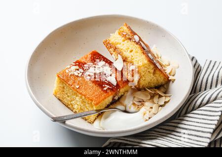 Gâteau israélien aux agrumes. Gâteau à la livre d'orange avec yaourt, amandes et sirop, fond blanc. Banque D'Images