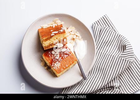 Gâteau israélien aux agrumes. Gâteau à la livre d'orange avec yaourt, amandes et sirop, fond blanc, vue de dessus. Banque D'Images