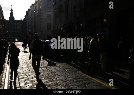 Silhouetted à l'extérieur du Coach and Horses Pub sont des piétons et des buveurs dans le soleil de l'après-midi. Romilly Street, Soho, Londres, Royaume-Uni. 29 septembre 2023 Banque D'Images