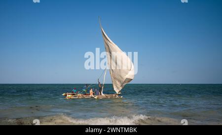 Les pêcheurs emmènent des touristes occidentaux pour un voyage dans leur boutre traditionnel à voile, Jambiani, Zanzibar, Tanzanie Banque D'Images