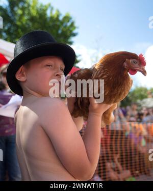 06/08/16 ***AVEC VIDÉO*** Brody Wordsworth, 6 ans, tient sa poule avant le début de la première manche.. Les foules encouragent les poules alors qu'elles concourent au Worl Banque D'Images