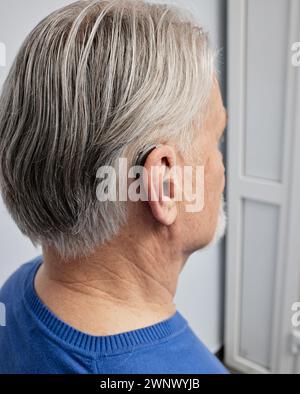 Prothèse auditive derrière l'oreille d'un homme âgé, gros plan. Solutions pour améliorer l'audition Banque D'Images