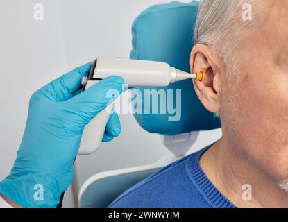 Portrait d'homme mature en tympanométrie et test de la fonction de l'oreille moyenne avec ORL-médecin utilisant la sonde tympanométrique au centre auditif, gros plan Banque D'Images