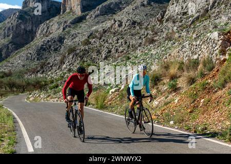 Jeunes et mi-adultes amis Cycling Up rural Mountain Road, Alicante, Costa Blanca, Espagne - photo stock Banque D'Images