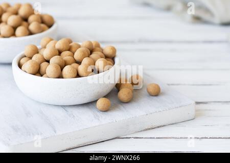 Pois chiches recouverts de soja marron avec sauce dans un bol en bois, noix turque traditionnelle enrobée Banque D'Images