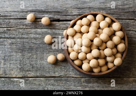 Pois chiches recouverts de soja marron avec sauce dans un bol en bois, noix turque traditionnelle enrobée Banque D'Images