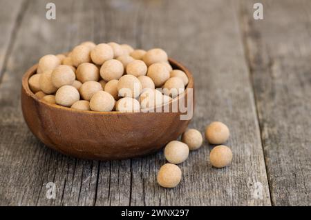 Pois chiches recouverts de soja marron avec sauce dans un bol en bois, noix turque traditionnelle enrobée Banque D'Images