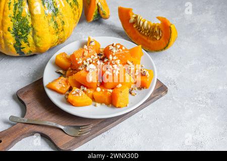 Dessert traditionnel à la citrouille turque avec sorbet sur table rustique et citrouilles fraîches tranchées Banque D'Images