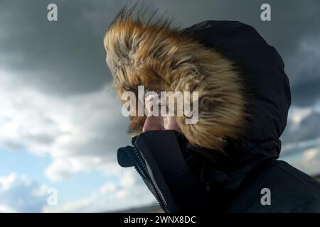 Portrait d'une femme dans un parc bordé de fourrure par mauvais temps Banque D'Images