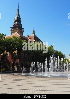 Subotica, Serbie, 12 septembre 2021. Fontaine sur la place de Subotica entre l'Hôtel de ville, le bâtiment du Théâtre National et la ville Banque D'Images