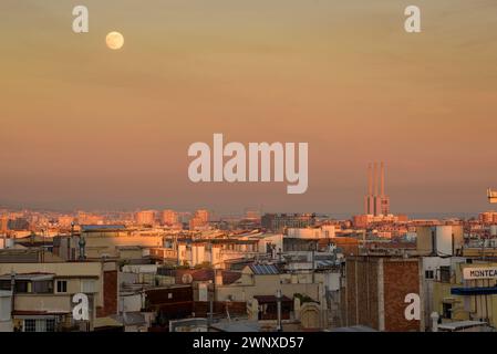 Coucher de soleil sur l'horizon de Barcelone avec la pleine Lune (Barcelone, Catalogne, Espagne) ESP : Atardecer sobre el skyline de Barcelona con la Luna llena Banque D'Images