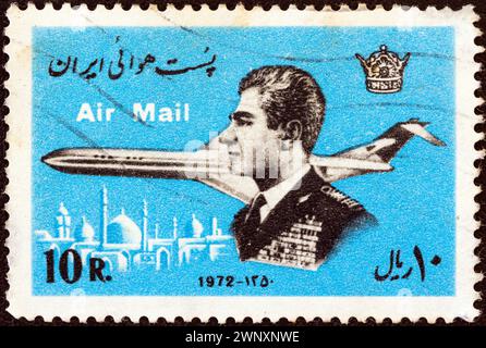 IRAN - VERS 1972 : un timbre imprimé en Iran montre Mohammad Reza Shah Pahlavi et un avion Banque D'Images