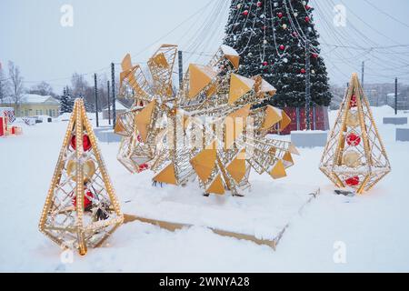 Petrozavodsk, Russie, 10 janvier 2024 : petites formes architecturales en forme de cônes lumineux et d'un grand cône, fait de guirlandes et d'ampoules Banque D'Images