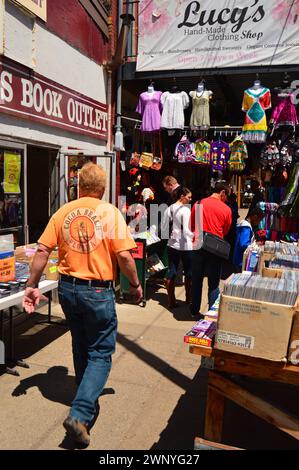 Les amateurs de bonnes affaires recherchent des vêtements et des livres vintage et usagés sur les trottoirs de vente dans le Strip District de Pittsburgh Banque D'Images