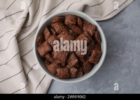 Tampons de céréales au chocolat dans un bol sur une table grise, vue de dessus Banque D'Images