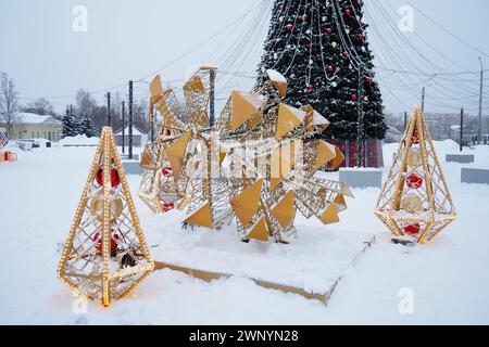 Petrozavodsk, Russie, 10 janvier 2024 : petites formes architecturales en forme de cônes lumineux et d'un grand cône, fait de guirlandes et d'ampoules Banque D'Images