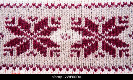 Motif tricoté jacquard. Ornement géométrique pour Noël ou nouvel an. Flocons de neige marron tricotés ou fleurs sur un fond beige. Tendance hivernale Banque D'Images
