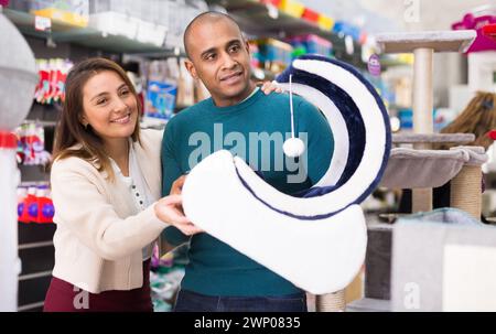 Couple choisissant des fournitures de meubles de chat en magasin Banque D'Images