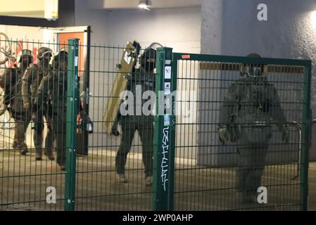 Berlin, Allemagne. 04 mars 2024. Des policiers équipés d'équipements spéciaux quittent un immeuble de grande hauteur à Berlin-Friedrichshain. Crédit : Dominik Totaro/dpa/Alamy Live News Banque D'Images