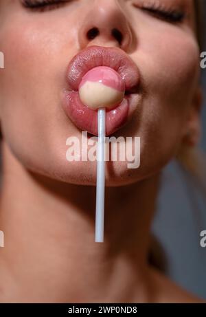 Lollipop dans la bouche de la femme. Girl lick, lollipop, gros plan. Bouche lécher Suck Chupa chups. Banque D'Images