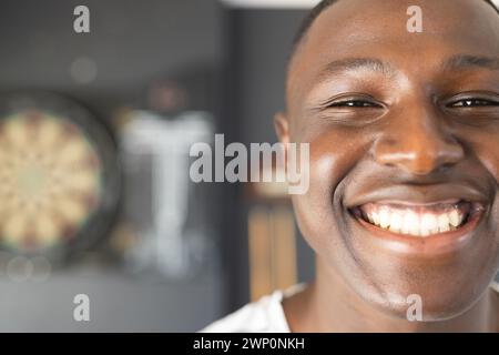 Un jeune homme afro-américain sourit largement, mettant en valeur une expression joyeuse avec un espace de copie Banque D'Images