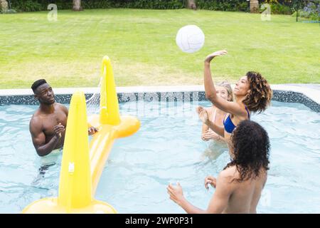 Groupe diversifié aime un jeu de billard, avec une jeune femme caucasienne lançant un ballon de volley Banque D'Images