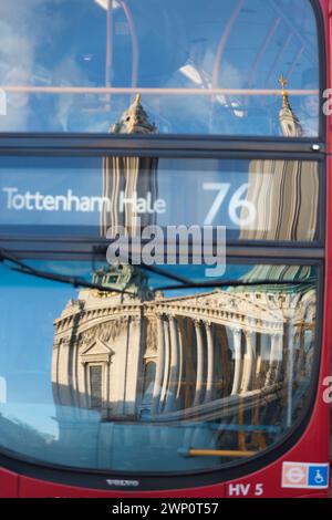 UK, Londres, Red London bus avec reflet de la cathédrale St Paul sur la fenêtre avant. Banque D'Images
