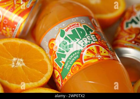 KIEV, UKRAINE - 7 JUILLET 2023 Mirinda boisson orange avec de nombreuses oranges fraîches sur fond coloré Banque D'Images