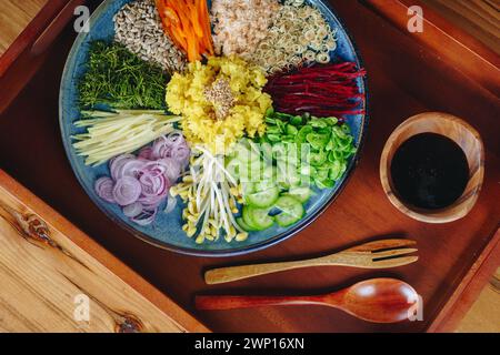 Une assiette de nourriture avec une variété de légumes et un bol de sauce. La scène est invitante et appétissante Banque D'Images