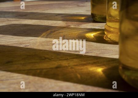 reflets du soleil des bouteilles d'huile d'olive sur une table en bois Banque D'Images