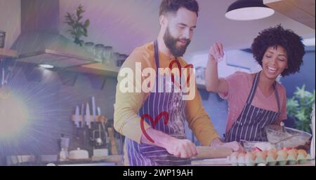 Image de coeurs ove couple diversifié préparant le repas dans la cuisine Banque D'Images