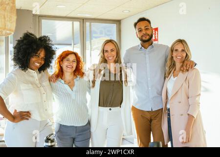 Groupe de gens d'affaires divers regardant la caméra et souriant tout en se tenant debout ensemble dans le bureau. Concept commercial. Banque D'Images