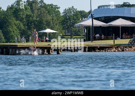 Aluksne, Lettonie - 19 juin 2021 : les jeunes sautent dans l'eau par une journée d'été ensoleillée dans le parc, lac Aluksne Banque D'Images