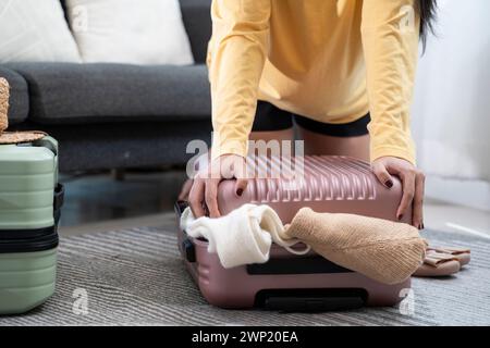 Femme emballant des vêtements dans une valise pour un voyage en vacances. Banque D'Images