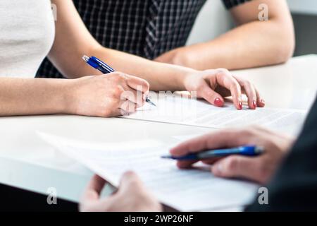 Accord de divorce. Couple signant un document légal. Règlement du mariage prénuptial, prénuptial. Réunion d'avocats. Séparation, rupture ou procès. Banque D'Images