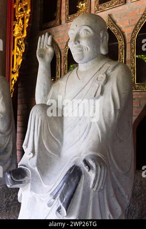 Gros plan sur l'une des nombreuses statues bouddhistes en pierre dans le complexe de pagodes du temple Bai Dinh à Ninh Binh, au nord du Vietnam. Banque D'Images