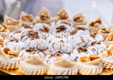 Photo horizontale un gros plan d'un plateau doré rempli de pâtisseries saupoudrées de noix, capturant l'essence de la confiserie du moyen-Orient dans un p festif Banque D'Images